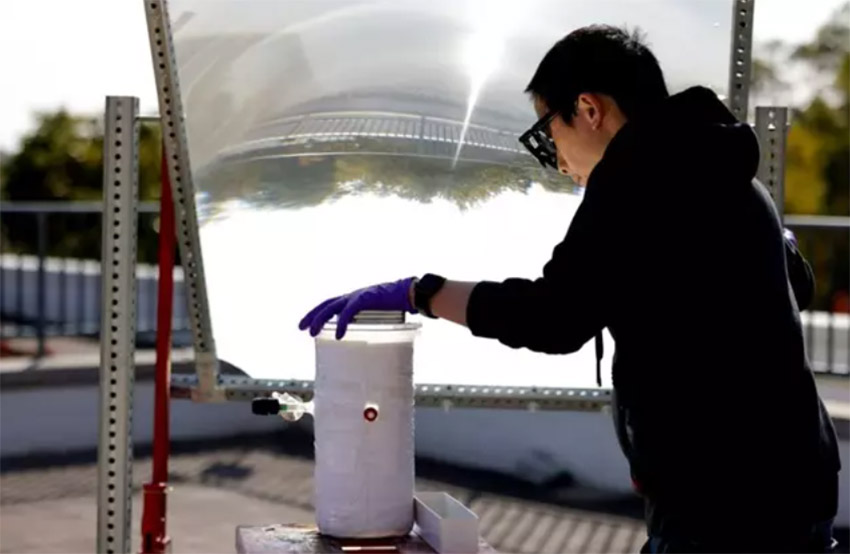 Peng Zhou utiliza una gran lente para concentrar la luz solar en el catalizador que divide el agua. - BRENDA AHEARN/MICHIGAN ENGINEERING, COMMUNICATIONS